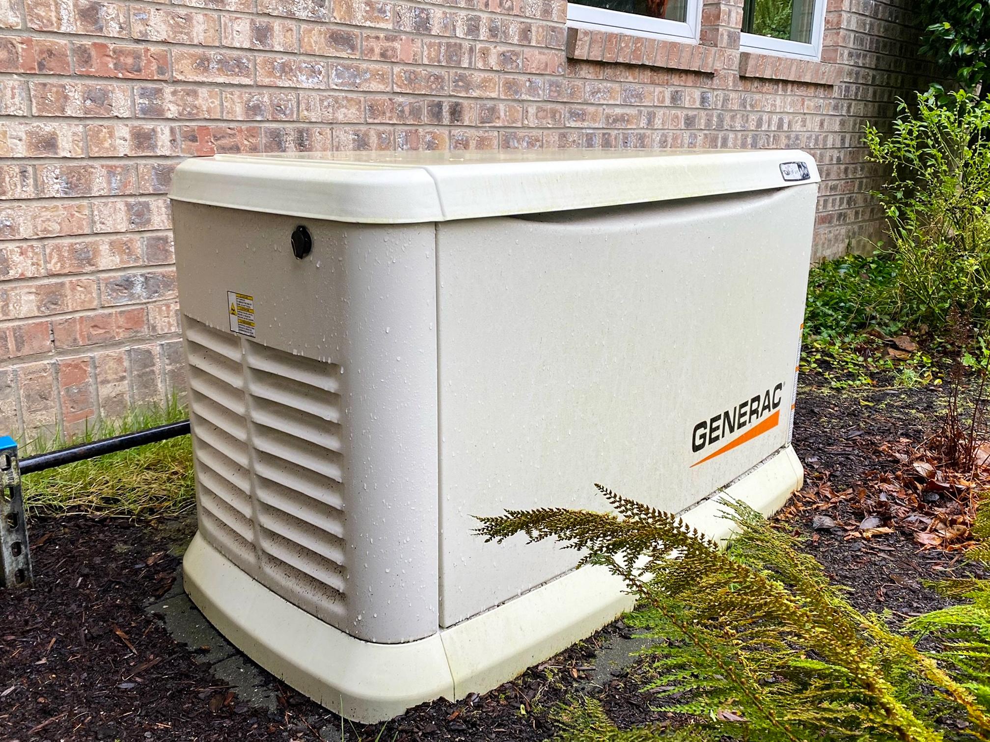 A Generac standby generator installed on a concrete pad beside a home.